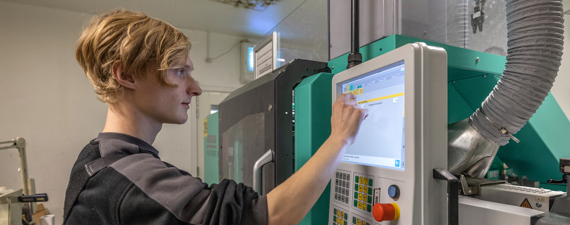 Plastmager betjener produktionsmaskine